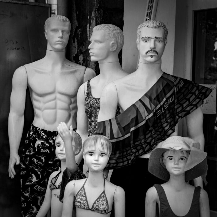 A group of fashion mannequins showcasing various styles in black and white.